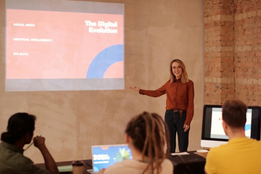 Woman presenting digital evolution slideshow to audience.