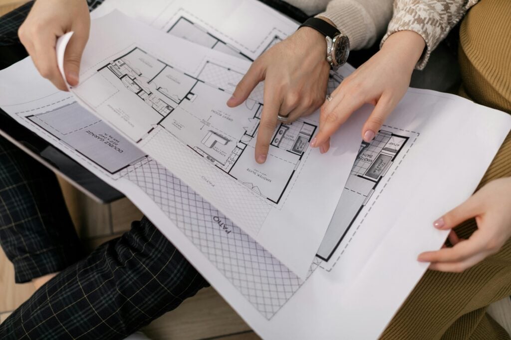 Two people examining architectural blueprints together.