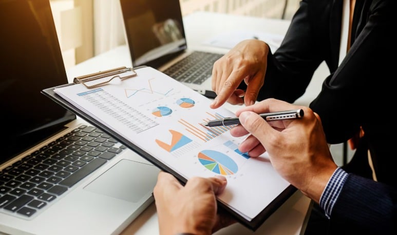 Business meeting analysing financial graphs and statistics.