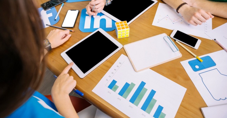 Business team brainstorming with tablets and graphs.