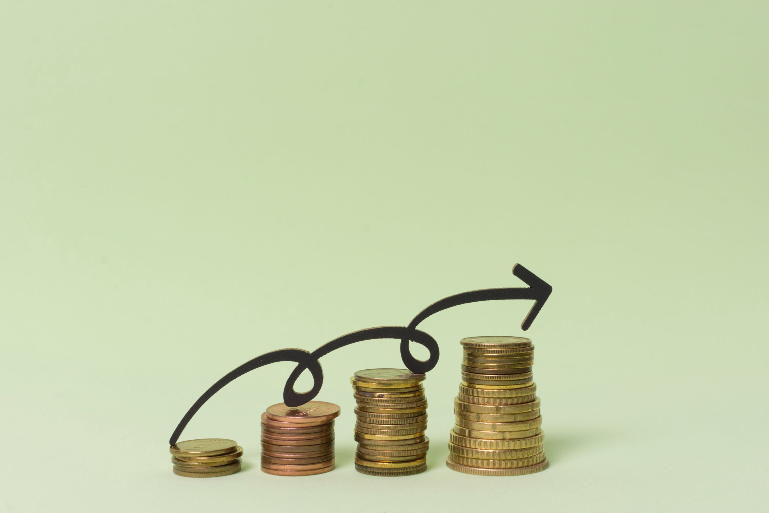 Increasing stacks of coins with upward arrow