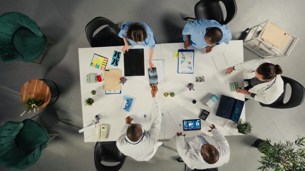 Doctors discussing patient X-rays in meeting.