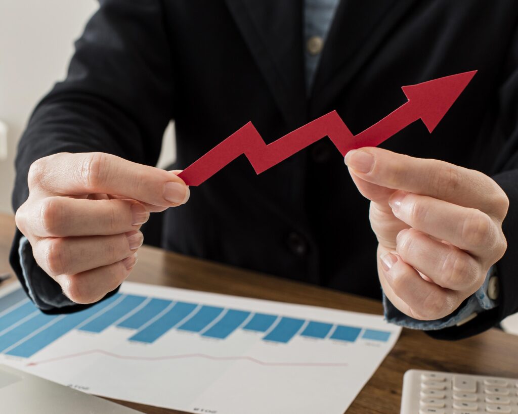 Person holding upward trending arrow, business growth concept.