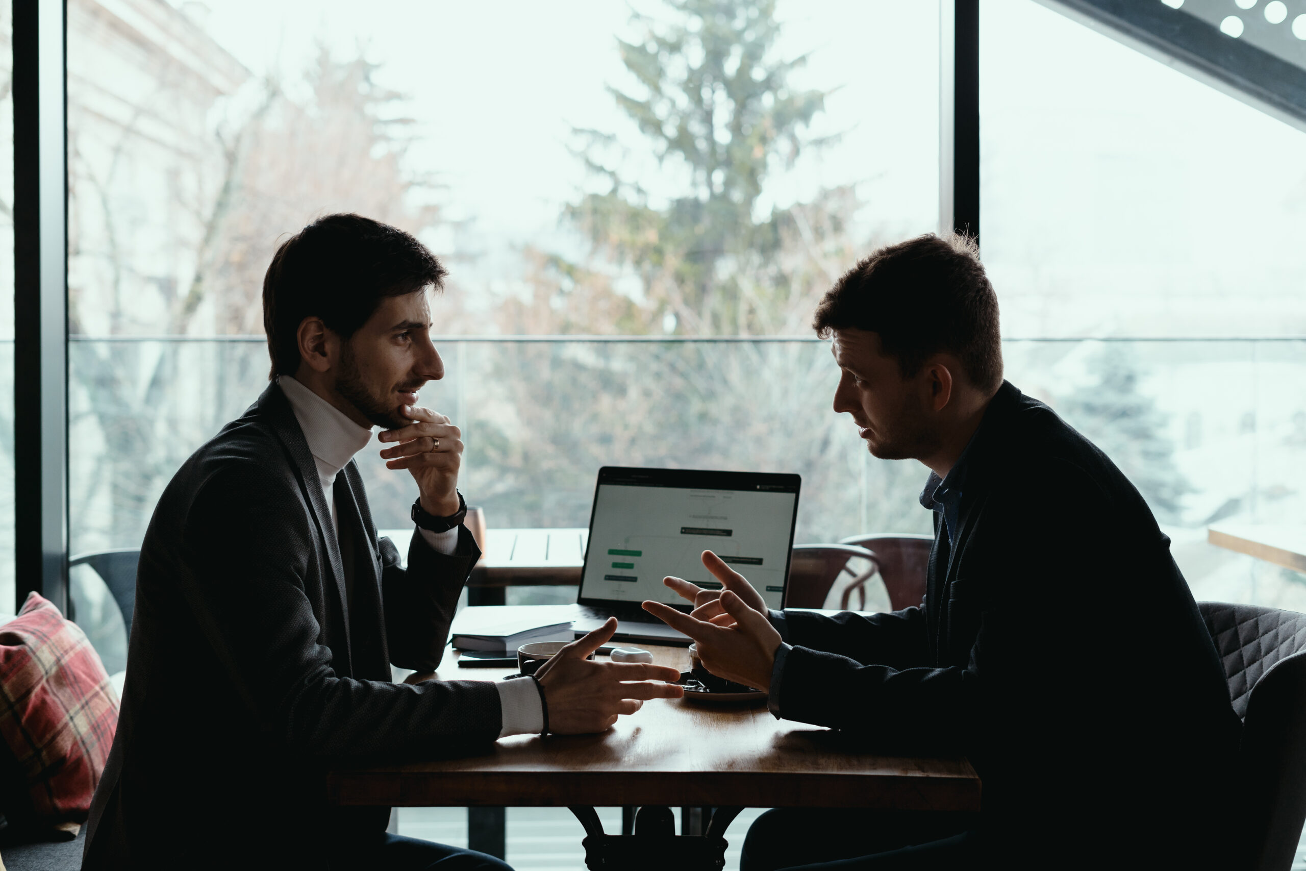 Two men discussing business at a table indoors.
