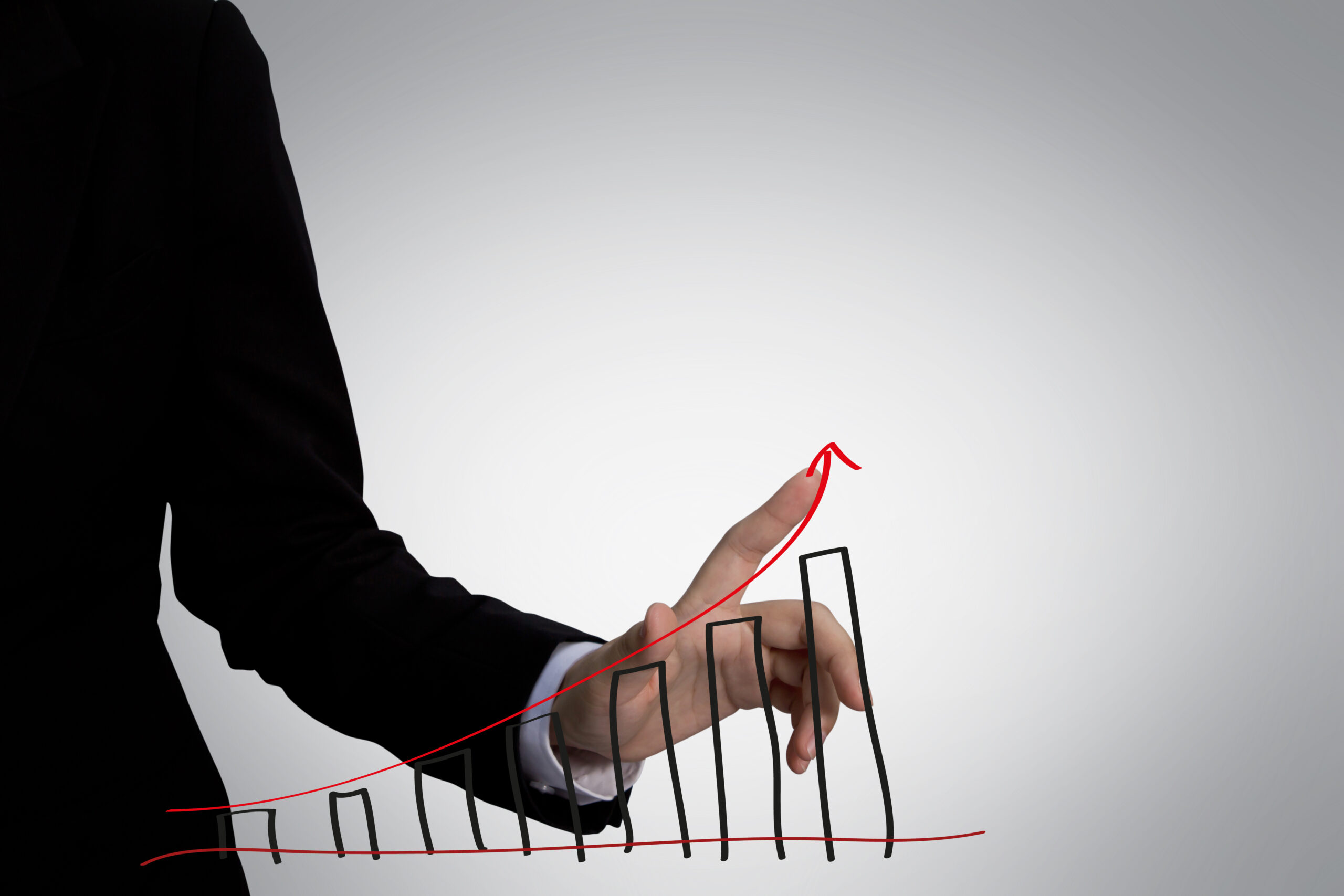 Businessperson tracking rising bar graph with finger.