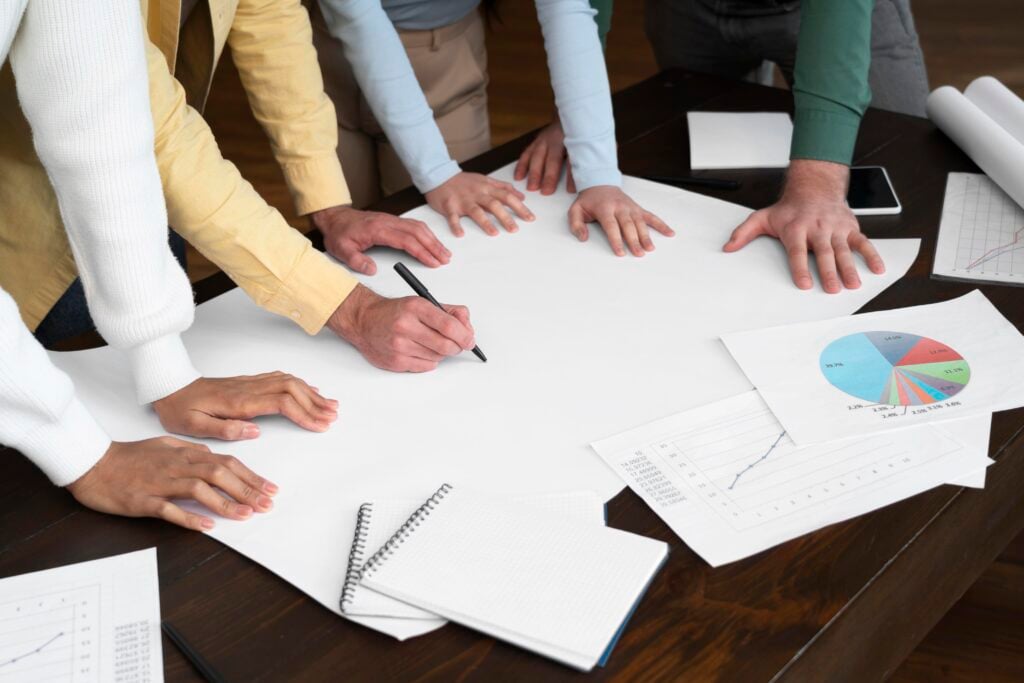 Group planning around table, writing on paper.