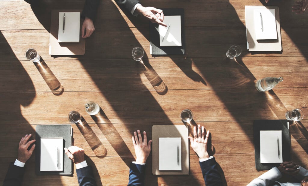 Business meeting with documents and water on table.