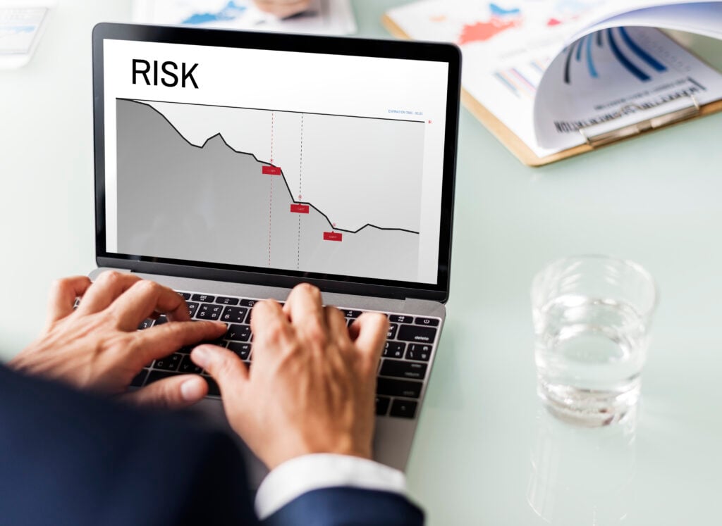 Laptop displaying risk analysis graph, person typing