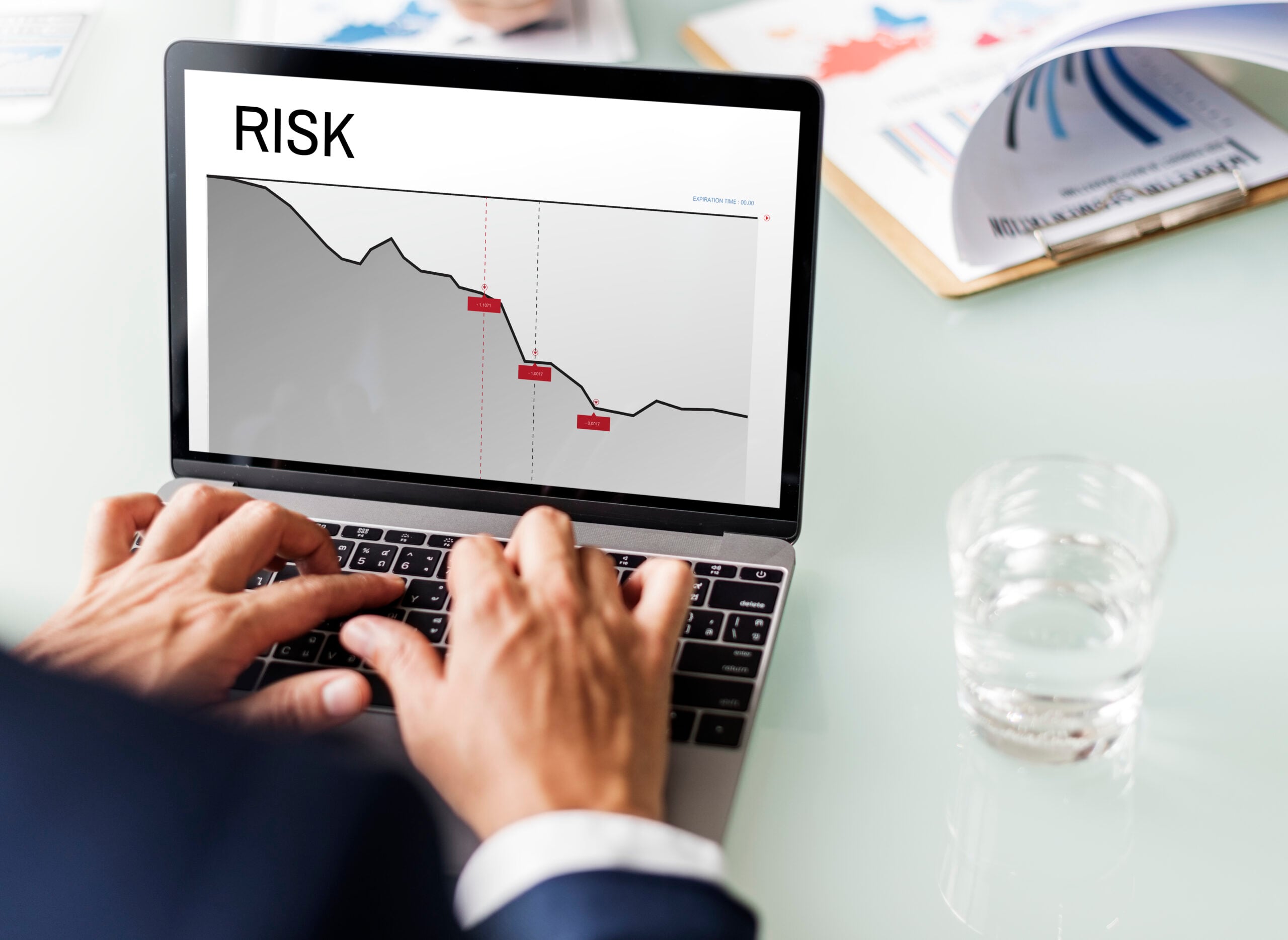Laptop displaying risk analysis graph, person typing