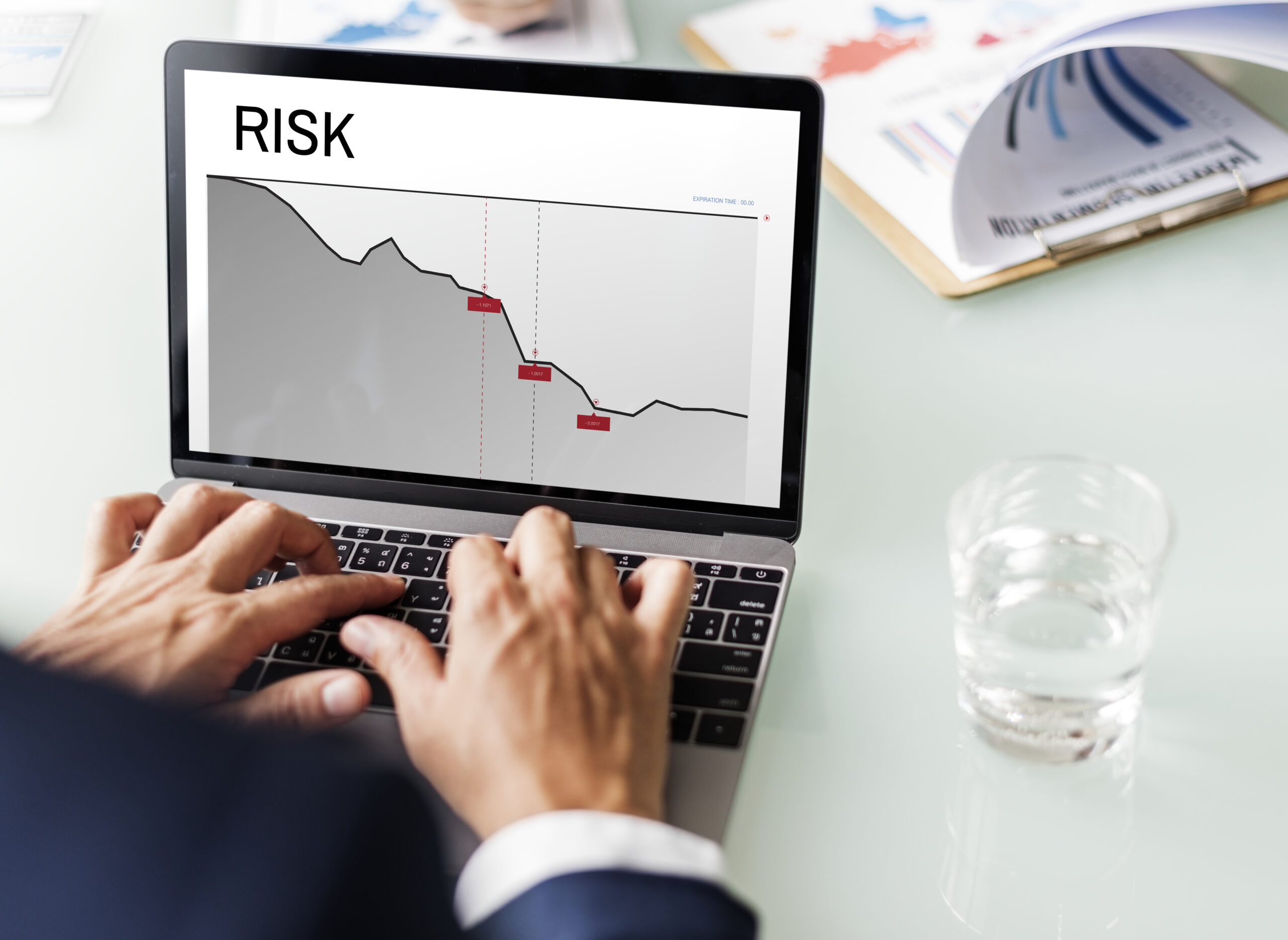 Person analysing risk graph on laptop screen.